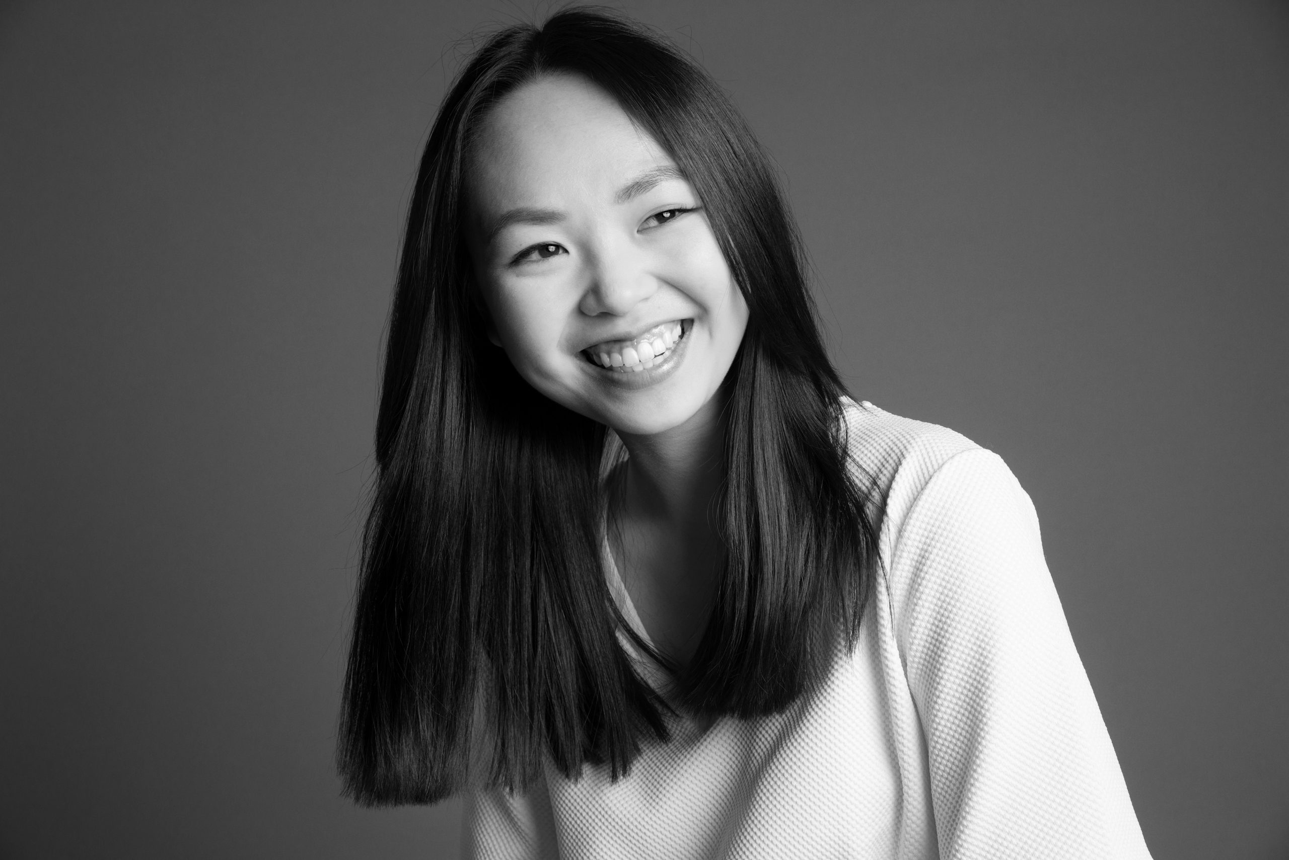 Schwarz-Weiß-Foto der Illustratorin Trang Do auf dem sie lacht